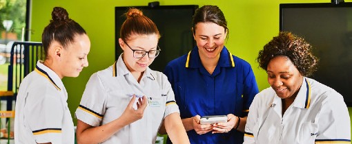 A group of nursing students inspecting a mock patient.
