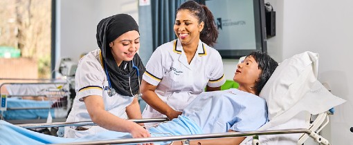 Image of two Adult Nursing students attending a mock patient.