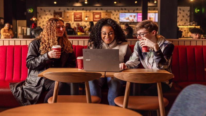 Three students looking at laptop