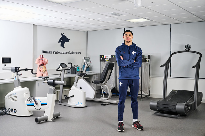Sports student standing with arms crossed in the Human Performance Laboratory