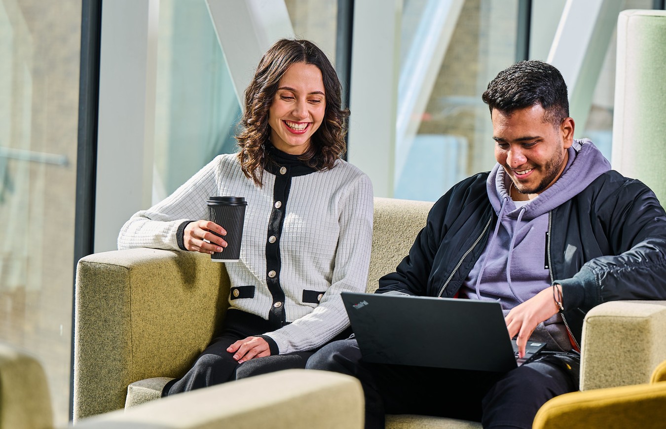 Two students looking at a laptop