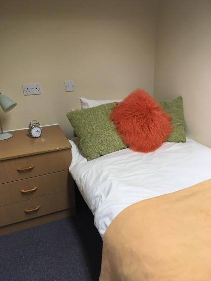 A bedroom in Telford Campus accommodation, with a bed next to a bedside table