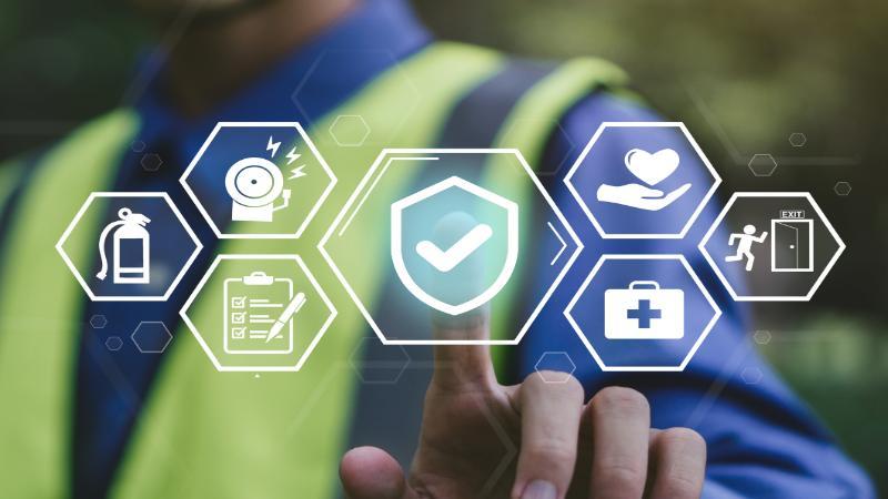 Images of health and safety symbols on a glass screen with a hand pointing to them