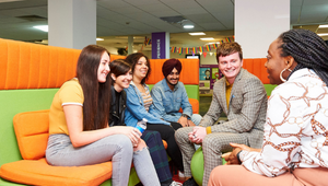 A group of students sat together in a communal area.