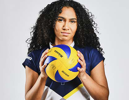 A woman in WLV sports clothes holding a football