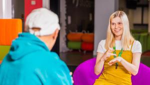 a female student signs and smiles