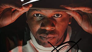 Xidus Pain looking into the camera and tilting his cap with both hands