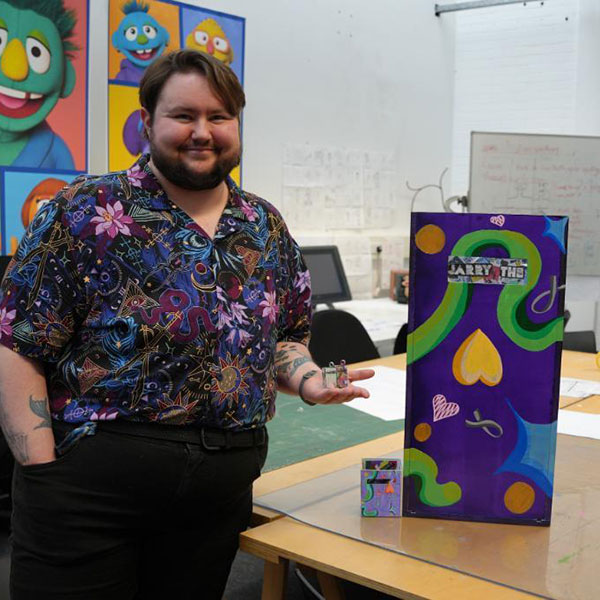 Photograph of Samuel McCracken presenting art pieces