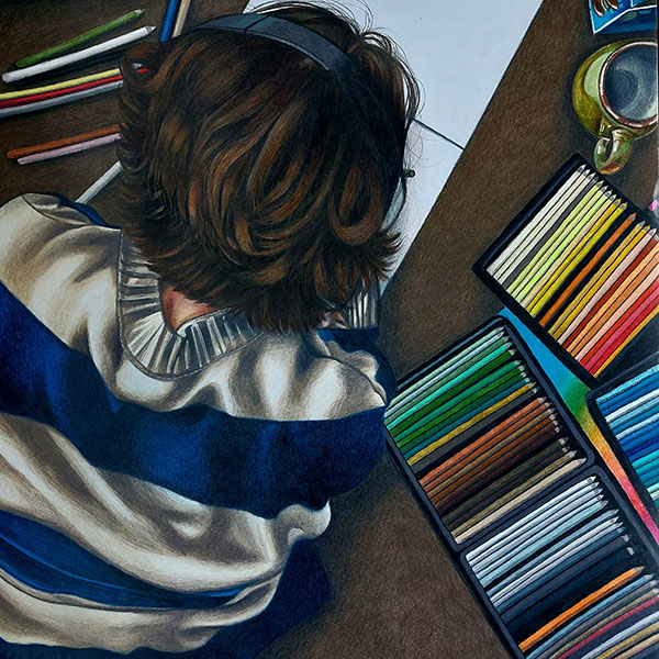 Drawing of a person with shoulder-length curly hair wearing a white and blue striped jumper and headphones, working on a drawing pad surrounded by sets of coloured pencils and a drinking mug.