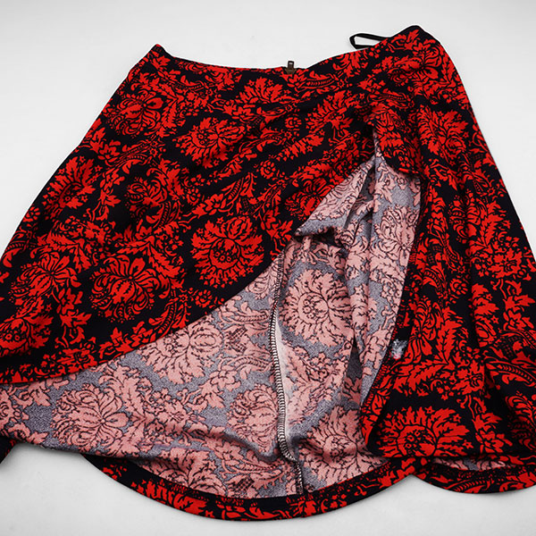 Photograph of a red and black skirt with ornate floral patterning.