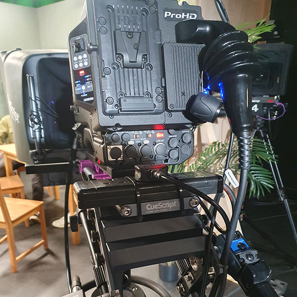 Photograph of a film camera placed in a living room, pointed at a dining table