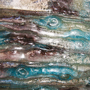 close up image of an abstract glass sculpture with white, green and purple shades