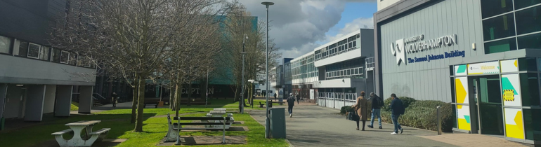 Two people in high-visibility vests looking at a building plan between them.