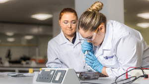 A student in a lab coat using scientific equipment