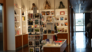 Shelves stocked with artwork, books, pens and postcards