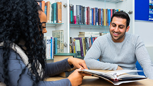 two students looking over a book