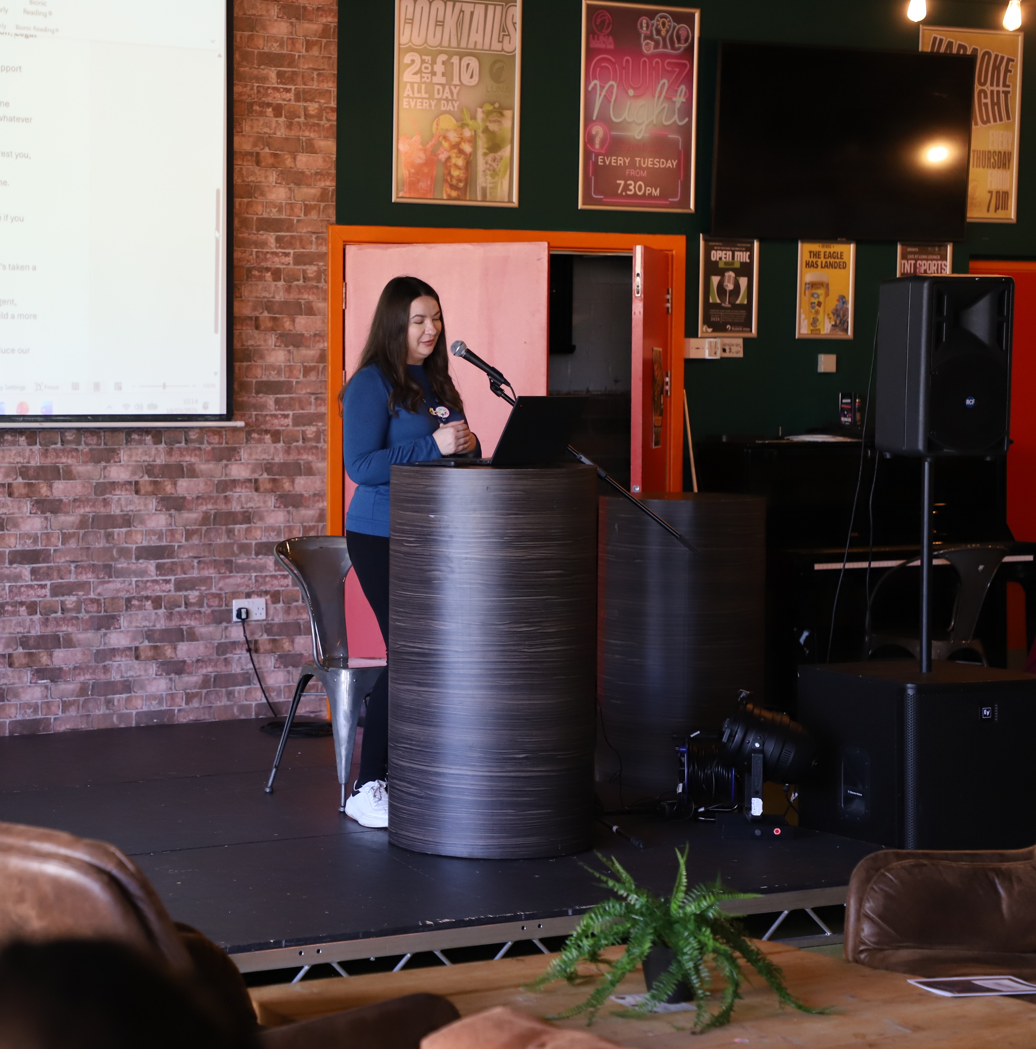 female disability and inclusion adviser standing on stage delivering a talk