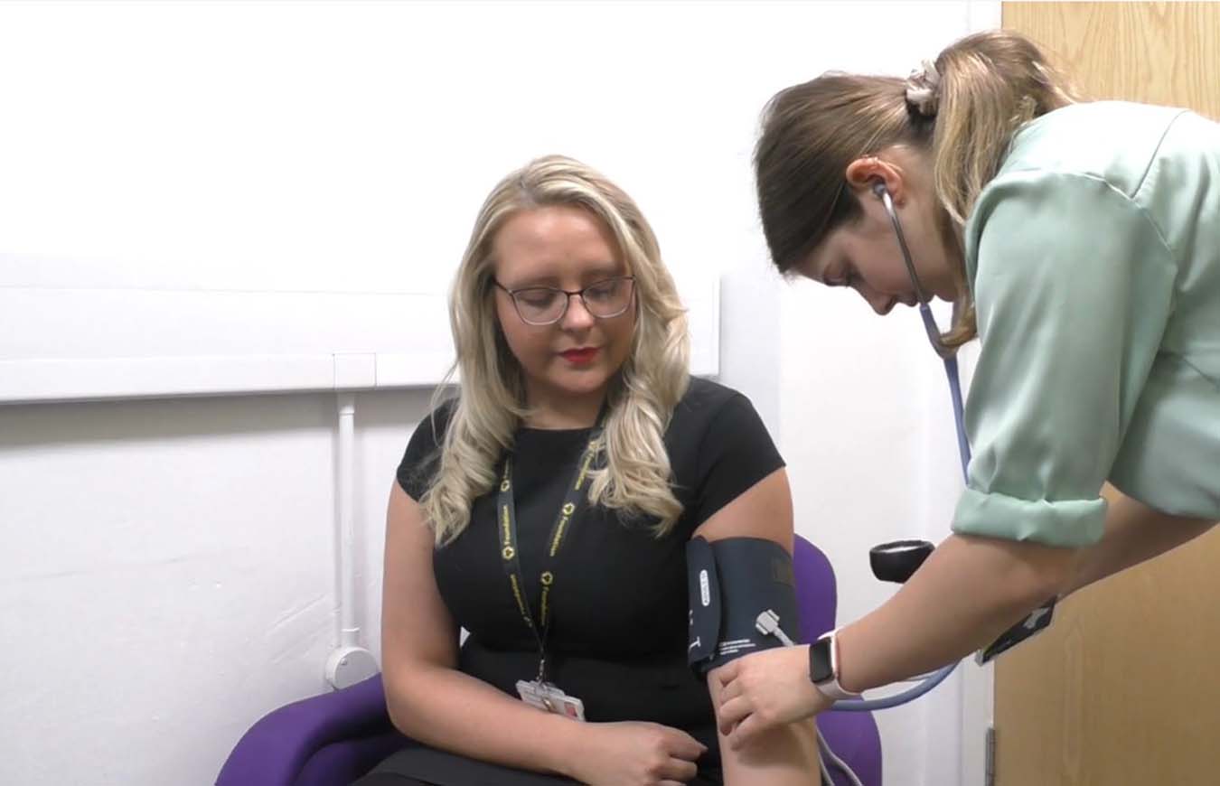 staff member getting a blood pressure check at a wellbeing check
