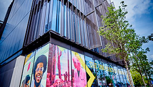 Exterior of the Rosalind Franklin building on Wolverhampton City Campus, a tall building with large windows decorated with large photographs of students.
