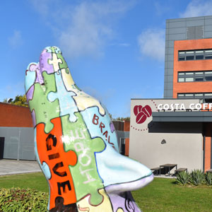 A photograph of a statue of a wolf with a jigsaw pattern design on it. This is taken in the courtyard of our City Campus.