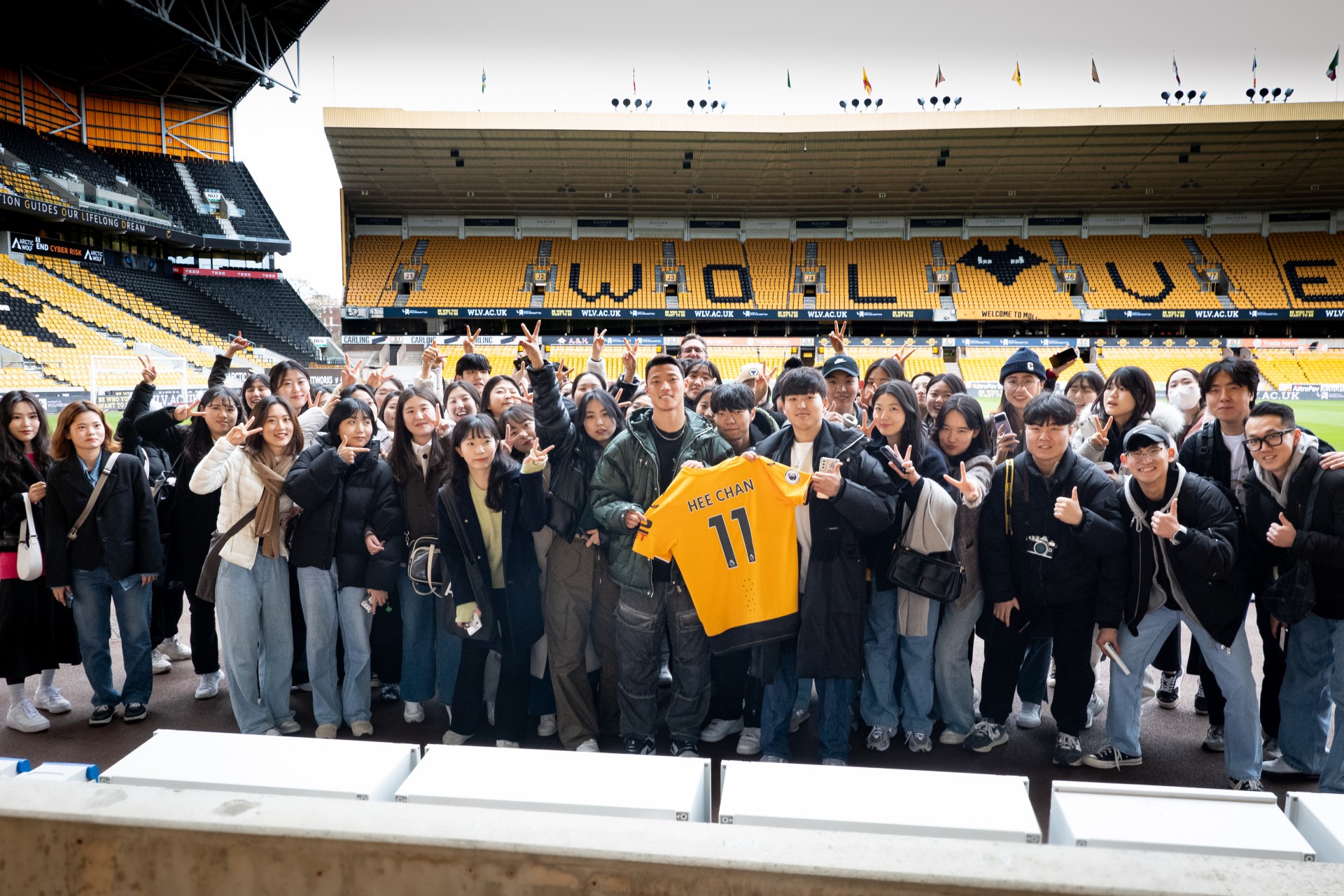 Group of Wolves fans posing with Hwang Hee Chan and his Wolves club shirt