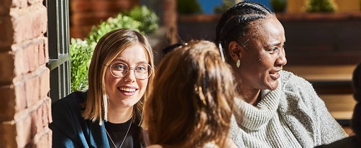 Photograph of Postgraduate research students sat around a wooden table.