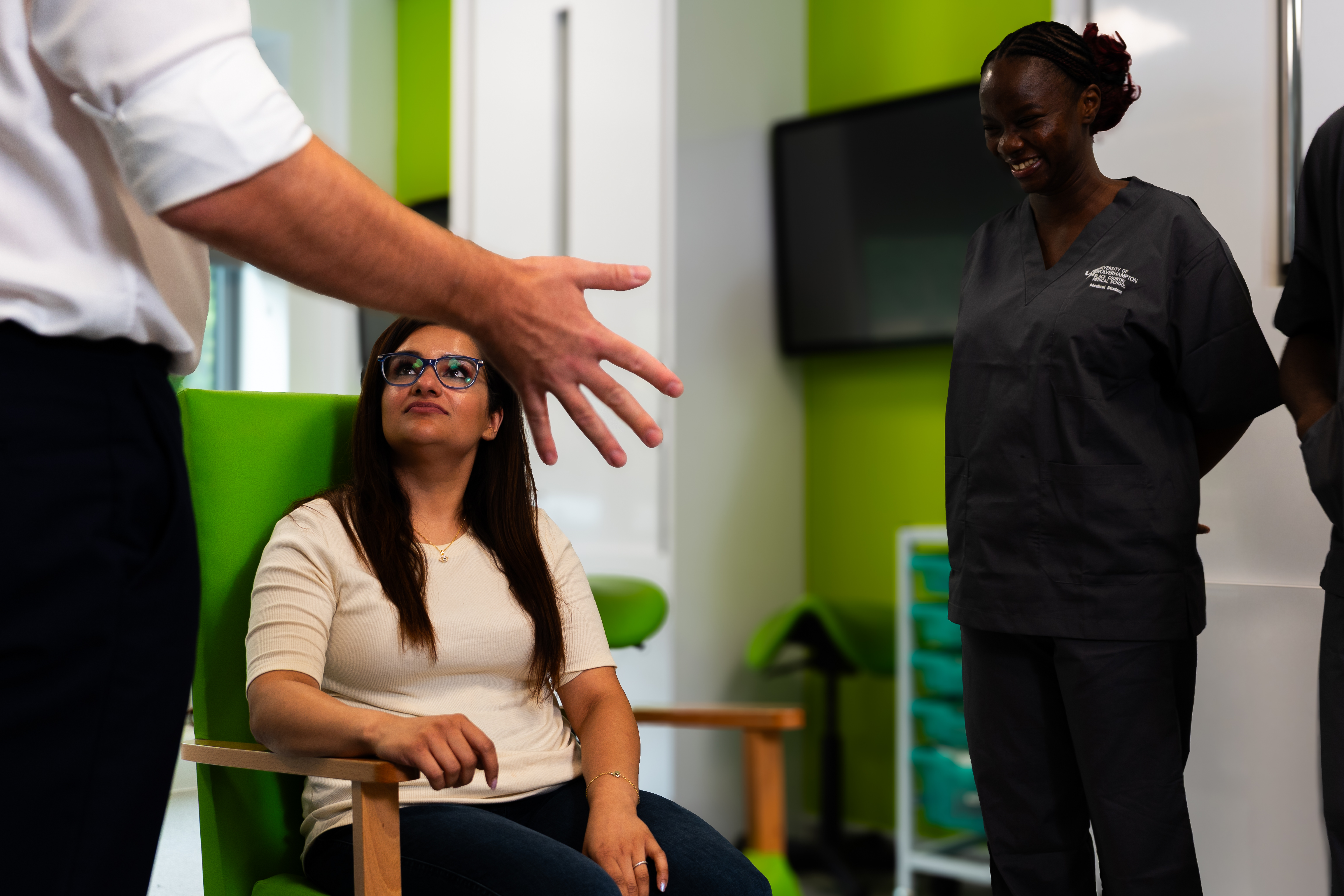 A woman sitting in a chair being consulted by nursing students