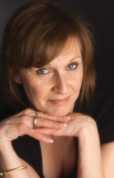 Hilary looking at camera with hands under chin