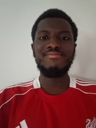 Ibrahim smiling at camera wearing a red top