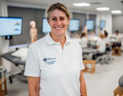 Student Vanessa smiling at camera in uniform and in clinic