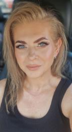 Ludmilla sitting in car, smiling at camera