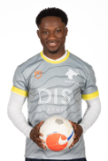 Male student standing, smiling at camera, holding a football