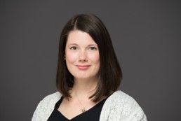 A professional woman smiles at the camera