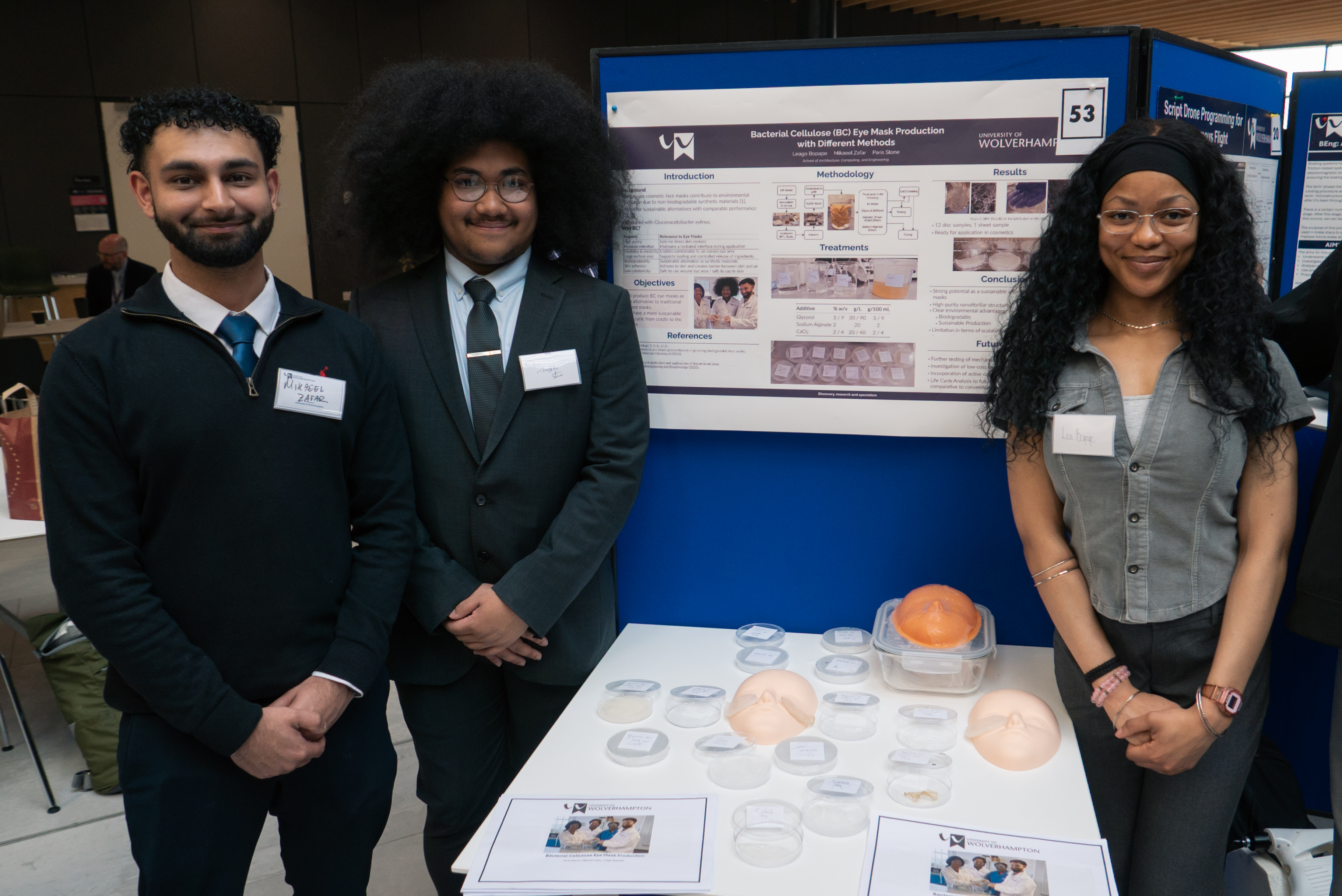 3 Chemical Engineering students standing proudly aside their materials presentation at the end of year show at Springfield site.