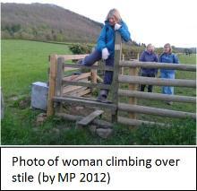 Woman climbing over a stile
