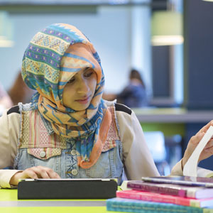 Student studying in the library with books