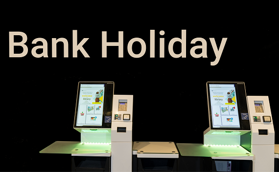 2 self Service Kiosks with the wording 'Bank Holiday' printed on the wall behind