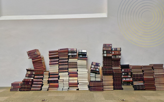 Stacks of old Journals up against a wall in a blank space