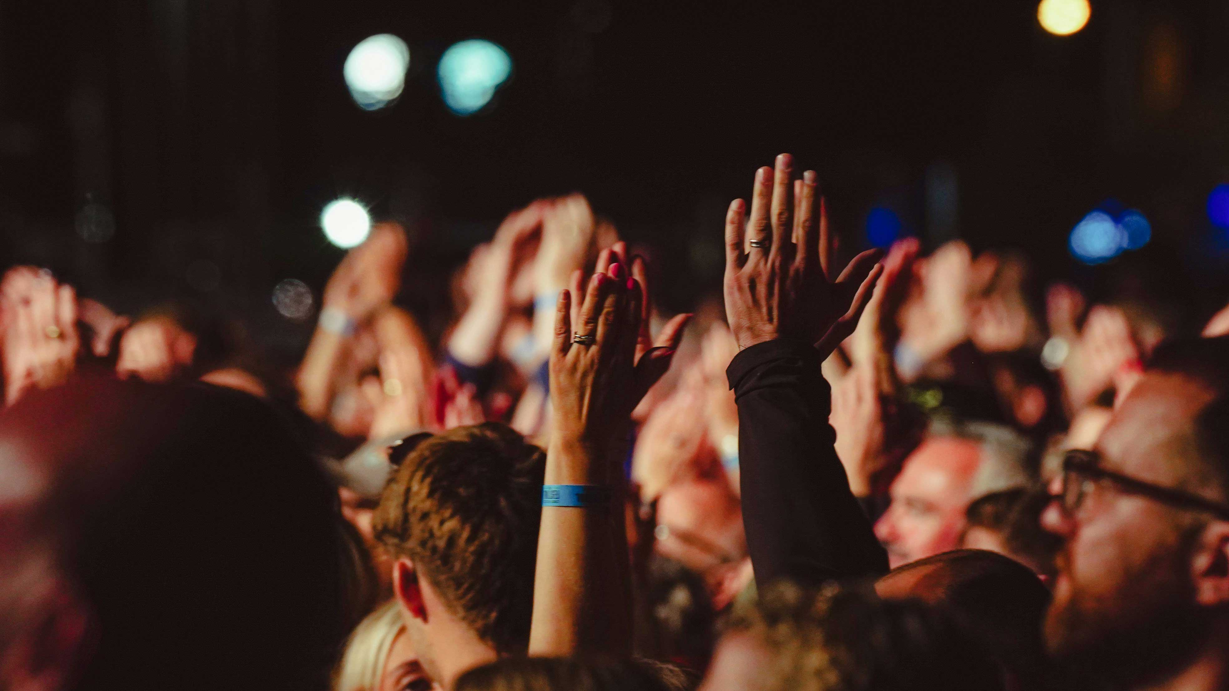 people clapping with their arms raised in the air