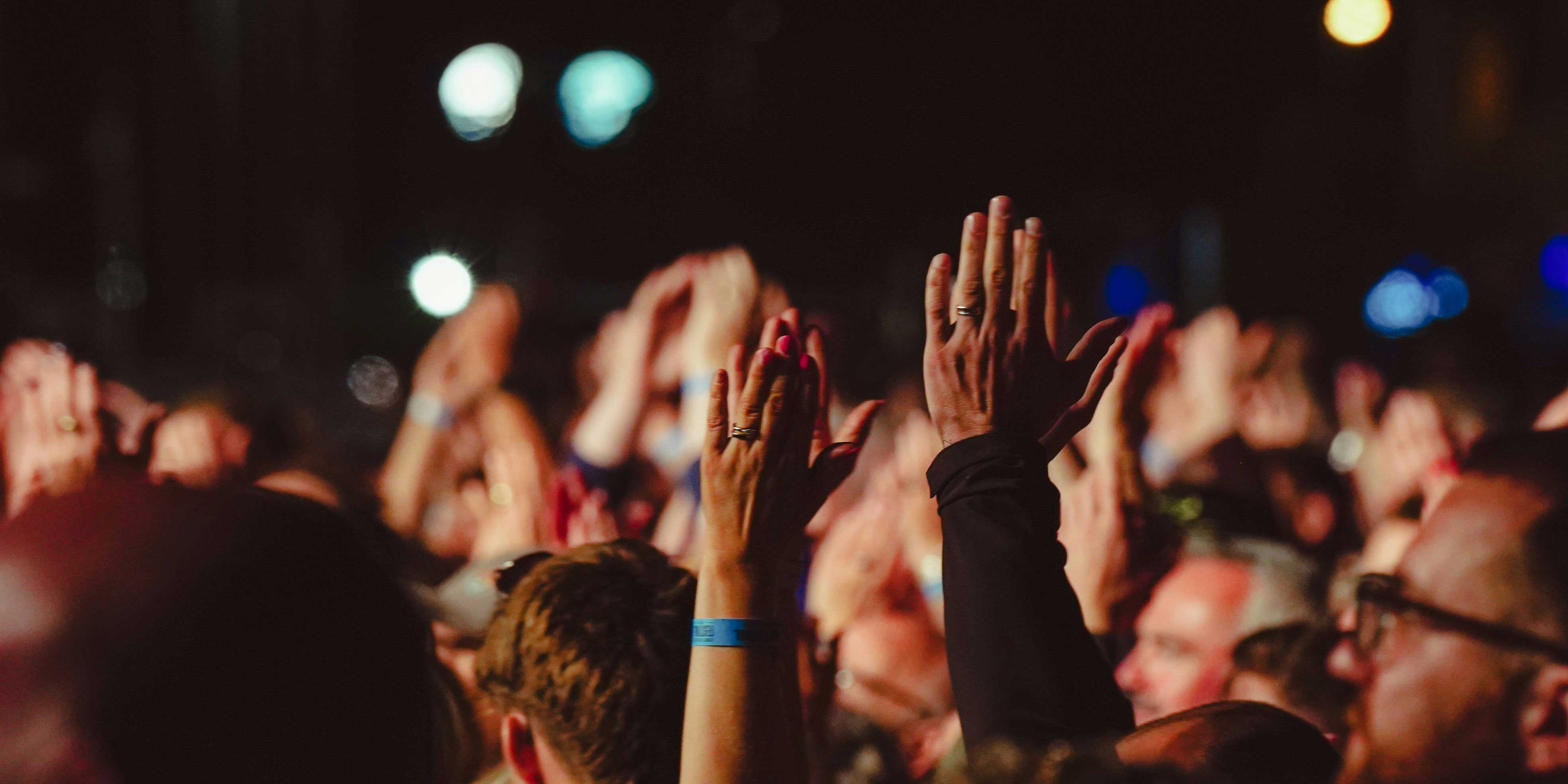 people clapping with their arms raised in the air