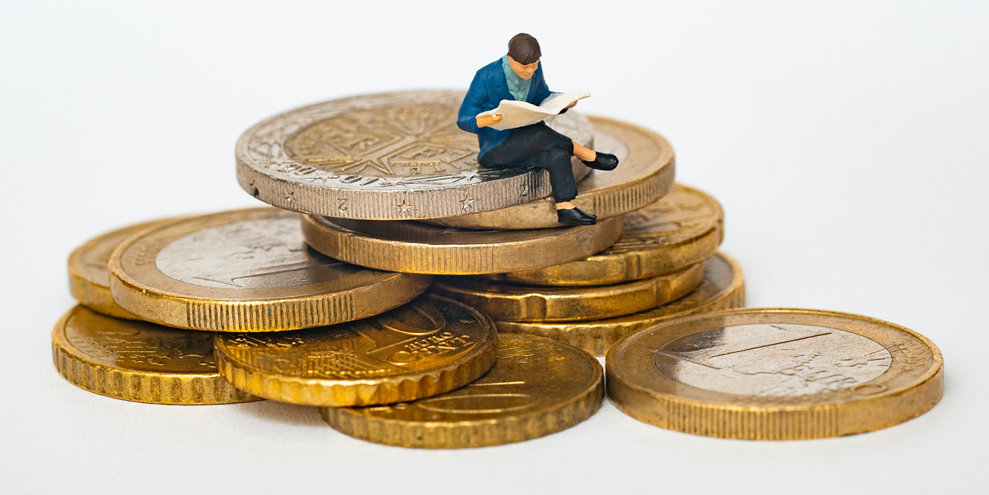 A man reading while sitting on a pile of coins