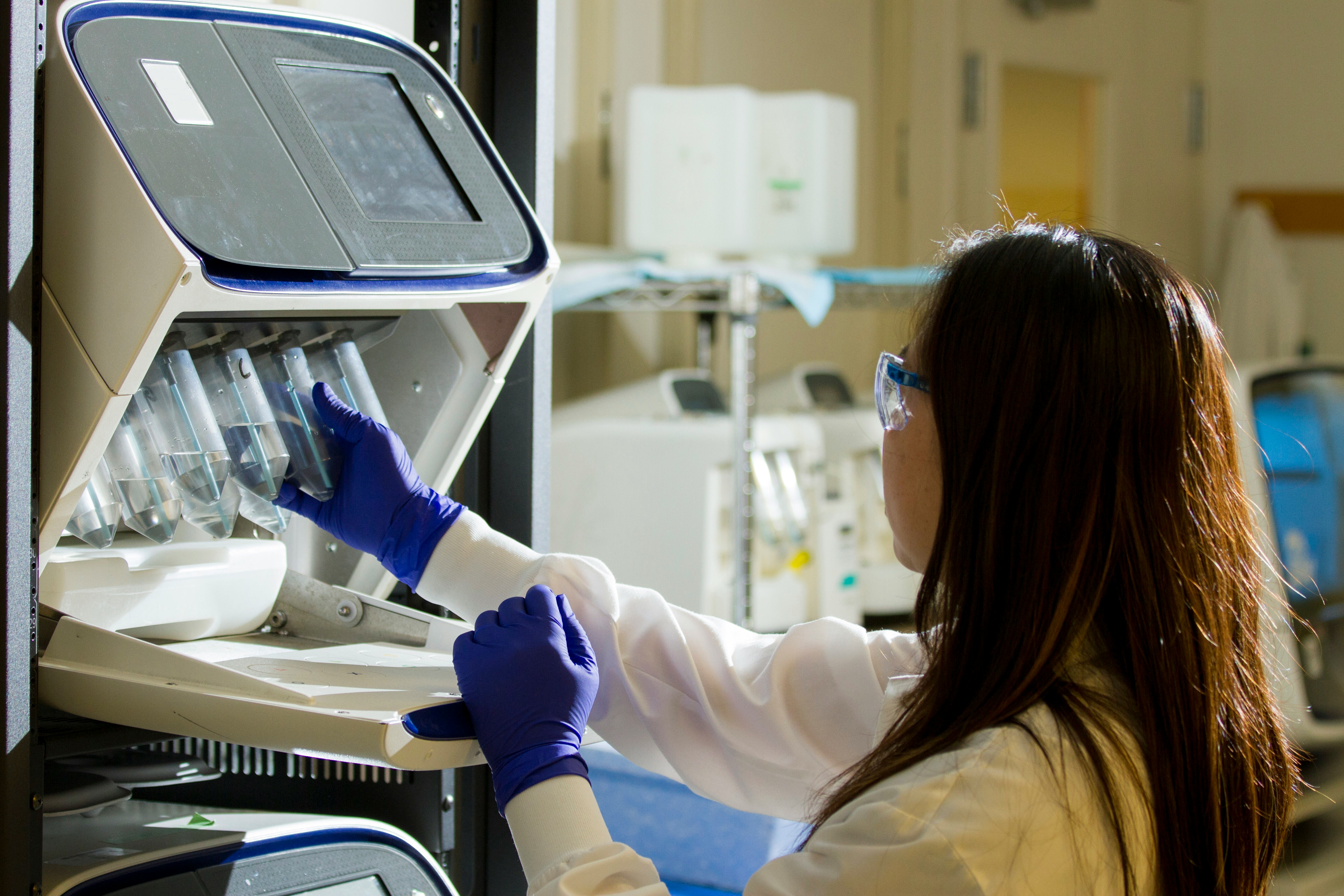 A scientist moving lab equipment around