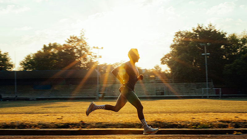 a man running in a park as the sun is setting