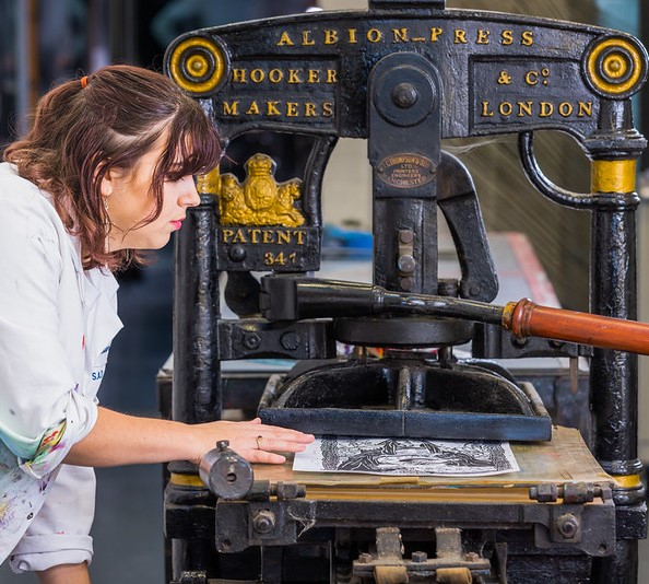 Student using a printing press