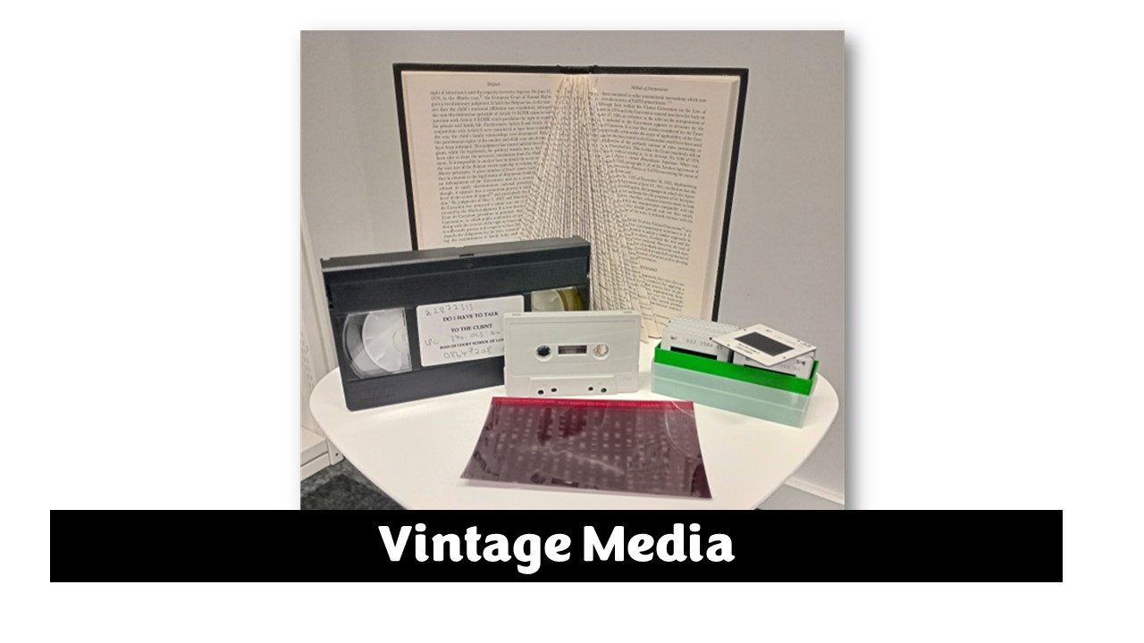 Photo of a VHS tap, cassette, slides and a microfiche