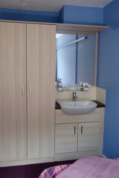 Image of a bedroom in Gorway accommodation, Walsall, showing a sink and wardrobe