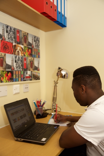 Image of a room in Telford accommodation, showing a boy at a desk using a laptop