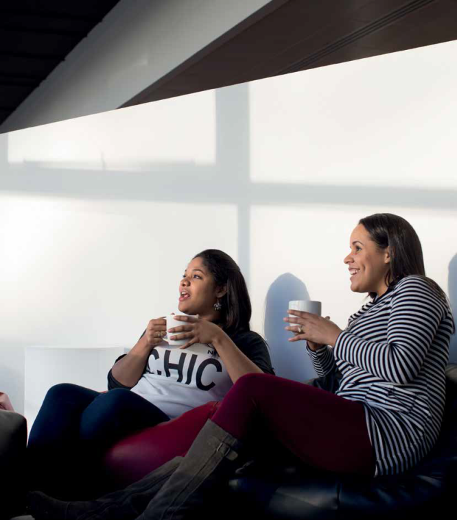 Two girls sitting together and drinking coffee