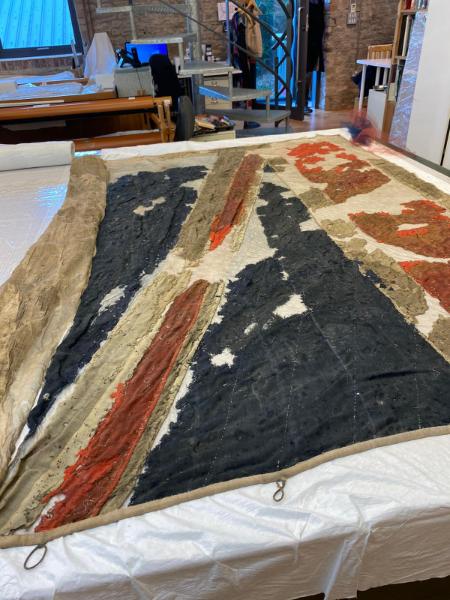 Union Jack flag of the HMS Captain in the process of professional restoration.