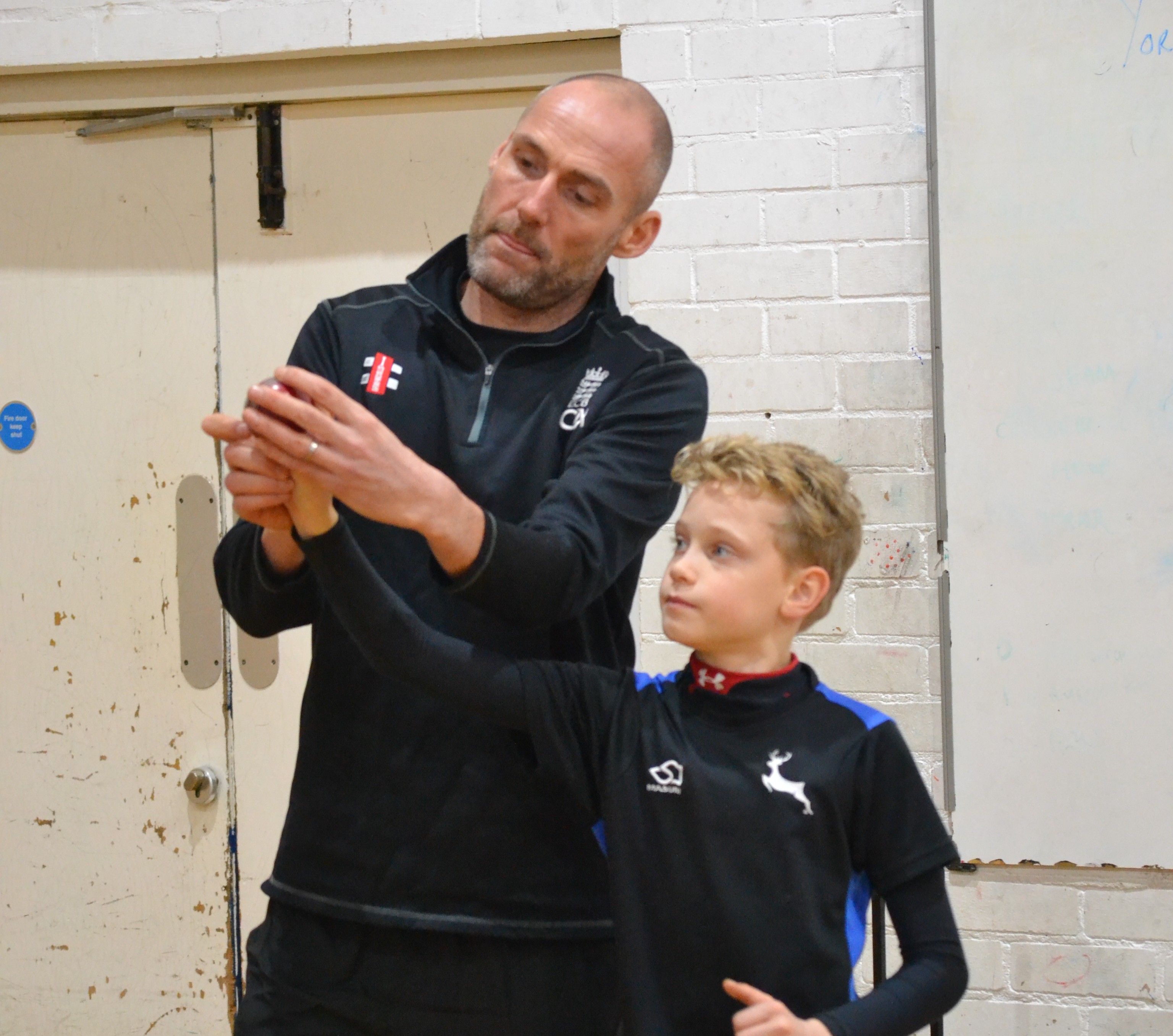 A photo of Scott Boswell and a child during a sports demonstration